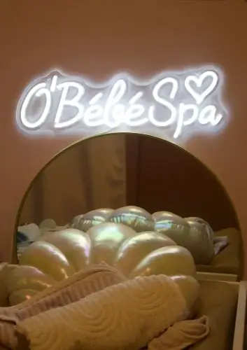 Enseigne néon O’Bébé SPA au-dessus d’un espace cocooning pour bébés à Marseille